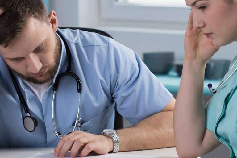 doctor reviewing medical notes with nurse