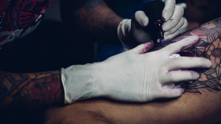 tattoo artist adding new design on customer